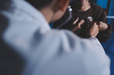 Ev bakımı hemşiresi ve yaşlılar kardiyoloji sağlık hizmetleri. Genç İspanyol kadın doktor hemşirenin yakın çekimleri sırasında steteskop kullanarak olgun beyaz hasta kalp atışlarını kontrol et.