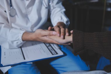 Dişi bir hemşire yaşlı bir kadını cesaretlendirmek ve teselli etmek için el ele tutuşur. Emeklilik yaşındakiler için bakım ve bakım evleri. Bakıcı yaşlı kadınlara tıbbi tavsiyelerde bulunuyor.