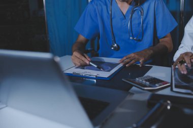 Doktorlar tedavi seçeneklerini tartışmak ve iş arkadaşlarıyla deneyimleri paylaşmak için hastanede toplanıyorlar.