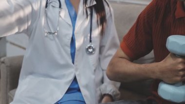 Dambıllar, fizik tedavi ve fizyoterapisti olan yaşlı bir adam, kas eğitimi ve yaşlı bakımı olan bir güç. Halter, rehabilitasyon ve ekipman için fizyoterapi kliniğinde sağlık, sağlık ve erkekler