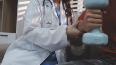 Dambıllar, fizik tedavi ve fizyoterapisti olan yaşlı bir adam, kas eğitimi ve yaşlı bakımı olan bir güç. Halter, rehabilitasyon ve ekipman için fizyoterapi kliniğinde sağlık, sağlık ve erkekler