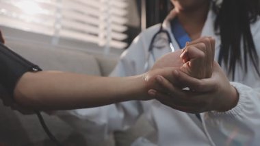 Doctor checking measuring pressure on patient's hand pulse