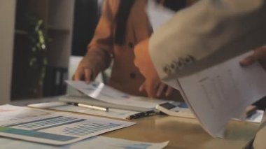 Finansal analistler, şirketlerin başarılı takım çalışmalarının sonuçlarını gösteren bir toplantıda bir dijital tablet planlama yatırım projesinin ticari mali raporlarını analiz ediyorlar..