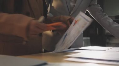 Finansal analistler, şirketlerin başarılı takım çalışmalarının sonuçlarını gösteren bir toplantıda bir dijital tablet planlama yatırım projesinin ticari mali raporlarını analiz ediyorlar..