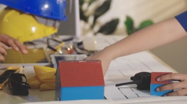 İki mimar planları analiz ediyor ve ofis ortamındaki bir inşaat projesi hakkında detaylı bir tartışmaya girişiyorlar.