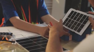 İki mimar planları analiz ediyor ve ofis ortamındaki bir inşaat projesi hakkında detaylı bir tartışmaya girişiyorlar.