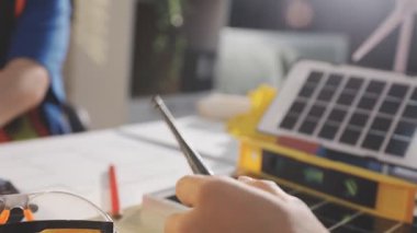 İki mimar planları analiz ediyor ve ofis ortamındaki bir inşaat projesi hakkında detaylı bir tartışmaya girişiyorlar.