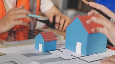 İki mimar planları analiz ediyor ve ofis ortamındaki bir inşaat projesi hakkında detaylı bir tartışmaya girişiyorlar.