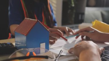 İki mimar planları analiz ediyor ve ofis ortamındaki bir inşaat projesi hakkında detaylı bir tartışmaya girişiyorlar.