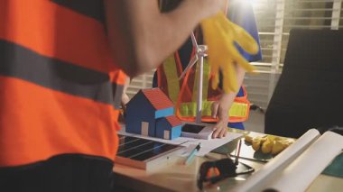 İki mimar planları analiz ediyor ve ofis ortamındaki bir inşaat projesi hakkında detaylı bir tartışmaya girişiyorlar.