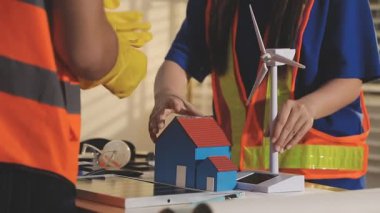 İki mimar planları analiz ediyor ve ofis ortamındaki bir inşaat projesi hakkında detaylı bir tartışmaya girişiyorlar.