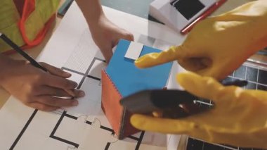 İki mimar planları analiz ediyor ve ofis ortamındaki bir inşaat projesi hakkında detaylı bir tartışmaya girişiyorlar.