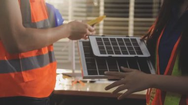 İki mimar planları analiz ediyor ve ofis ortamındaki bir inşaat projesi hakkında detaylı bir tartışmaya girişiyorlar.