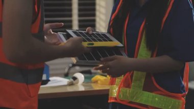 İki mimar planları analiz ediyor ve ofis ortamındaki bir inşaat projesi hakkında detaylı bir tartışmaya girişiyorlar.