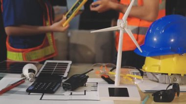 İki mimar planları analiz ediyor ve ofis ortamındaki bir inşaat projesi hakkında detaylı bir tartışmaya girişiyorlar.