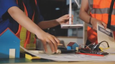 İki mimar planları analiz ediyor ve ofis ortamındaki bir inşaat projesi hakkında detaylı bir tartışmaya girişiyorlar.