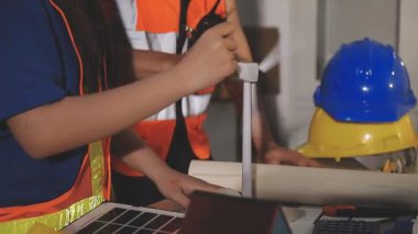 İki mimar planları analiz ediyor ve ofis ortamındaki bir inşaat projesi hakkında detaylı bir tartışmaya girişiyorlar.