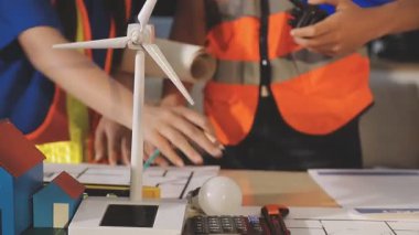 İki mimar planları analiz ediyor ve ofis ortamındaki bir inşaat projesi hakkında detaylı bir tartışmaya girişiyorlar.