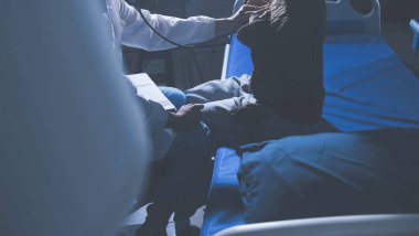 Ev bakımı hemşiresi ve yaşlılar kardiyoloji sağlık hizmetleri. Genç İspanyol kadın doktor hemşirenin yakın çekimleri sırasında steteskop kullanarak olgun beyaz hasta kalp atışlarını kontrol et.