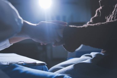 Dişi bir hemşire yaşlı bir kadını cesaretlendirmek ve teselli etmek için el ele tutuşur. Emeklilik yaşındakiler için bakım ve bakım evleri. Bakıcı yaşlı kadınlara tıbbi tavsiyelerde bulunuyor.