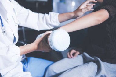 Evde dambıl kullanarak fizyoterapist eğitimi alan yaşlı bir kadın. Terapist, huzurevi egzersizlerinde yaşlı kadına yardım ediyor. Yaşlı bir hasta kollarını uzatmış halterler kullanıyor..