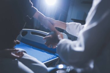 Evde dambıl kullanarak fizyoterapist eğitimi alan yaşlı bir kadın. Terapist, huzurevi egzersizlerinde yaşlı kadına yardım ediyor. Yaşlı bir hasta kollarını uzatmış halterler kullanıyor..