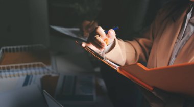 İki iş adamı toplantı odasında proje stratejisi hakkında konuşuyor. İş adamı, mali veri raporu hakkında sohbet ve tavsiyelerde bulunurken, modern işyerindeki iş arkadaşıyla proje planlamasını tartıştı.