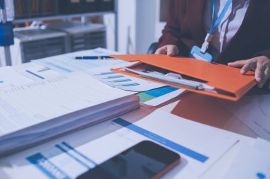 Muhasebe şirketi kârlı nakit akışı için finansman ve vergilendirme planlaması, ofiste çalışan denetçi ve muhasebeci ekibi, mali verileri ve muhasebe kayıtlarını hesap makinesiyle analiz eder