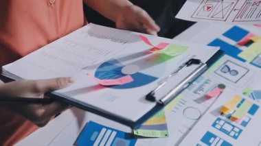 Uxui tasarımcılarından oluşan bir ekip bilgisayar ekranını işaret ederek ofiste yeni mobil uygulama tasarımını tartışıyor.