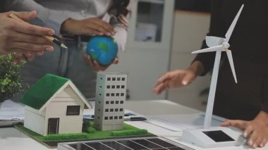 Ofiste bir ev modeliyle iş adamı var.