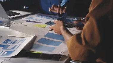 İş yerinde, ofiste bilgisayarla çalışan ve not defterine yazan genç adam.