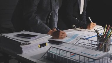 Takım elbiseli bir işadamı dizüstü bilgisayarla ofisinde oturuyor..