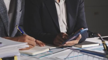 Tablet bilgisayar ve belgeler üzerinde çalışan iş adamı