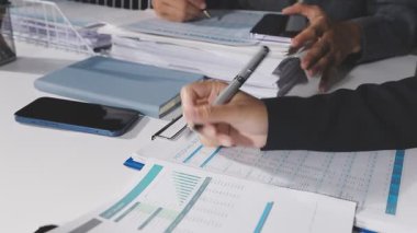 İş ekibi mali belgeler ve hesap makinesiyle çalışıyor