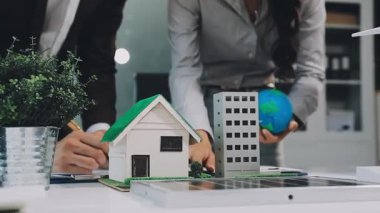 İş adamı model ev modelini elinde tutuyor.