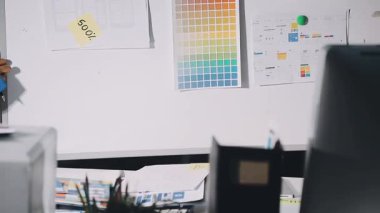 Ofisteki bilgisayarda çalışan tasarımcı.