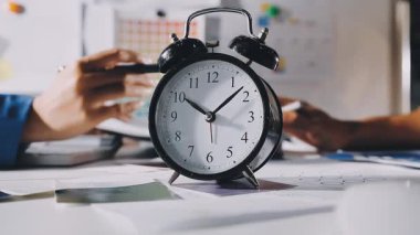 Ofis masasında saat ve dizüstü bilgisayar.