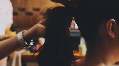 Güzellik salonunda, saç bakımında makasla saç kesen bir kadın.