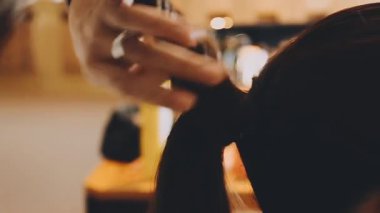 Saç stili yapan genç bir kadının yakın çekimi.