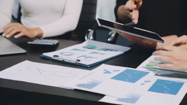 İşadamları ofiste mali belgeler ve dizüstü bilgisayar üzerinde çalışıyorlar.