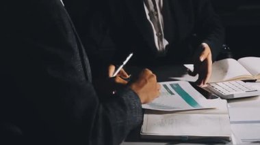 Genç işadamı ofisinde otururken not defterine yazı yazıyor.