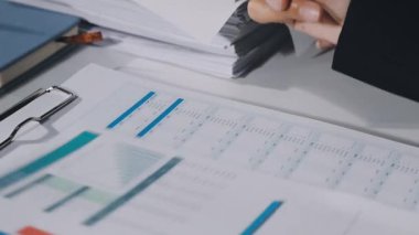 İş adamı hesap makinesindeki mali verileri analiz ediyor