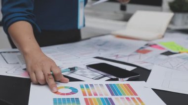 UXUI tasarımı üzerinde çalışan profesyonel bir kadın, bir arama sırasında mobil uygulama için kablolar ve modeller yaratıyor