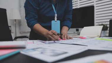 UXUI tasarımı üzerinde çalışan profesyonel bir kadın, bir arama sırasında mobil uygulama için kablolar ve modeller yaratıyor