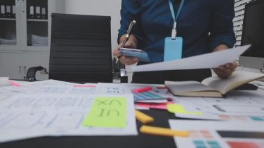 UXUI tasarımı üzerinde çalışan profesyonel bir kadın, bir arama sırasında mobil uygulama için kablolar ve modeller yaratıyor