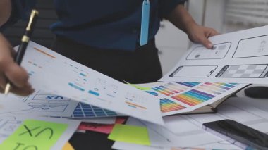 UXUI tasarımı üzerinde çalışan profesyonel bir kadın, bir arama sırasında mobil uygulama için kablolar ve modeller yaratıyor