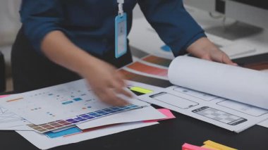 UXUI tasarımı üzerinde çalışan profesyonel bir kadın, bir arama sırasında mobil uygulama için kablolar ve modeller yaratıyor