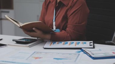 Muhasebe şirketi kazançlı nakit akışı için finansman ve vergilendirme planlaması, ofiste çalışan denetçi ve muhasebeci ekibi, mali verileri ve muhasebe kayıtlarını hesap makinesiyle analiz eder.