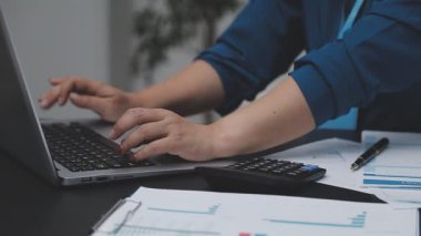 Muhasebe şirketi kazançlı nakit akışı için finansman ve vergilendirme planlaması, ofiste çalışan denetçi ve muhasebeci ekibi, mali verileri ve muhasebe kayıtlarını hesap makinesiyle analiz eder.