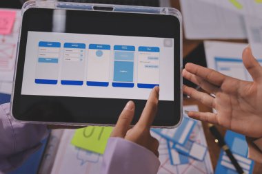 Mobil uygulama arayüzü kablo dizaynı hakkında modern ofisteki müşteri breif ve renk kodu ile fikir alışverişinde bulunan uu geliştirici ve ui tasarımcısını kapat. Yaratıcı dijital geliştirme ajansı.